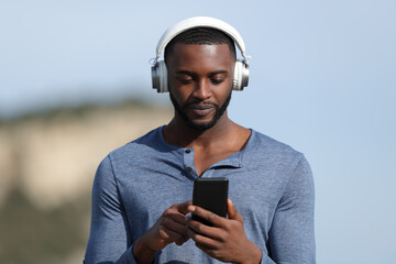Man with black skin wearing headset listening to music