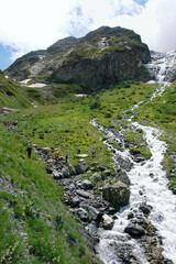 Summer landscape with Sofia waterfalls and group of tourists hiking on mountain plateau, natural background. trip, journey, adventure. Caucasus mountains, Karachay-Cherkess Republic. Arkhyz
