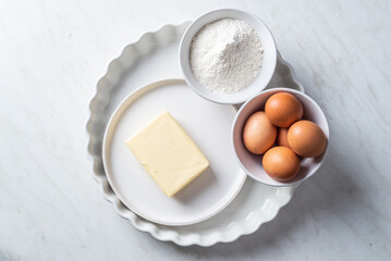 Empty tart form and tart ingredients on white backgound. White table with empty tart form