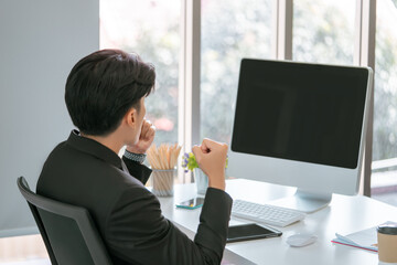 Businessman with winning gesture infront of a Blank computer screen for mock up and template of...