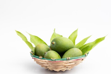 Closeup Of Fresh Raw Green Mangoes Also Called Kacha Khatta Aam With Leaves In Bamboo Basket. Isolated On White Background With Copy Space