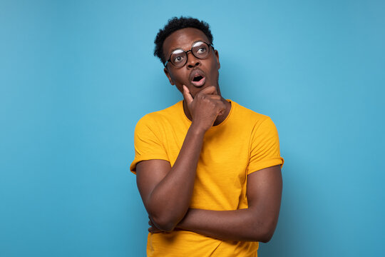 Young african american man with glasses looking up confident