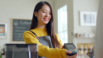 Customer using credit card for payment to owner at cafe restaurant, cashless technology and credit card payment concept
