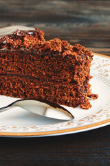 A piece of Chocolate cake on a plate on a wooden background.Slice of Homemade brownie cake.Copy space