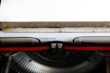 The German word Humanitär written on an old mechanical typewriter German Text: Humanitarian