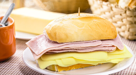 Brazilian breakfast, french salt bread with mozzarella cheese and ham, served with hot coffee and...