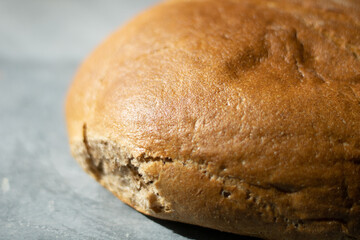 loaf of round black bread on gray background