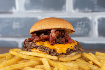 Smash burger with coleslaw sauce, bacon on top of a potato bed