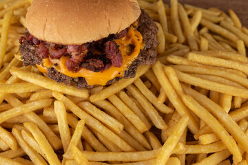 Smash burger com bacon e molho de queijo cheddar, bacon em cima de batata frita