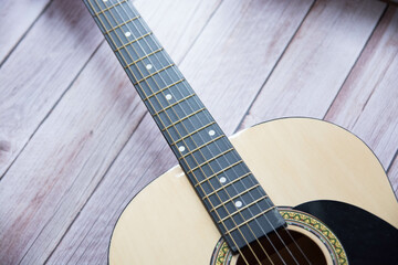 Obraz premium Preciosa guitarra acústica sobre fondo de madera