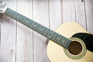 Obraz premium Preciosa guitarra acústica sobre fondo de madera