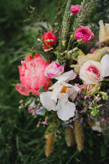 Beautiful modern bridal bouquet of colorful fresh flowers and greenery with silk ribbons. Classic wedding traditional accessory.