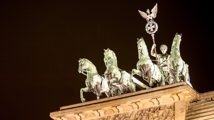 The Brandenburg Gate, Berlin, Germany. Night view of the Quadriga statue atop the Brandenburg Gate. © pxl.store