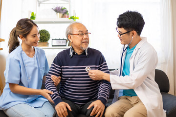 Obraz premium Young asian doctor helping elderly man get up from sofa .Health insurance concept, Elderly asian patients living at home checking by doctor and support by nurse, medicine health care for senior.