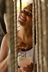 woman posing with cocktail on the swing 