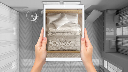 Hands holding tablet showing wooden bedroom with double bed, total blank project background, augmented reality concept, application to simulate furniture and interior design products