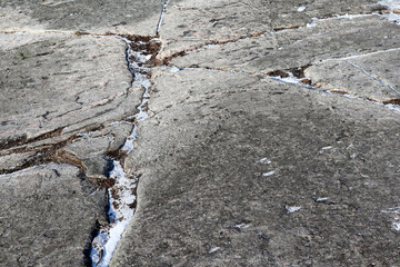cracks in rocks filled with snow close up