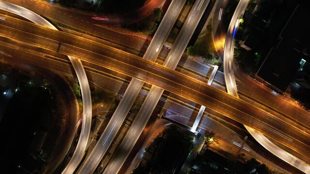 Hyperlapse time-lapse of car traffic transportation above intersection road in Bangkok city night, aerial view cityscape of advanced innovation, financial technology