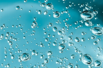 Close up macro Aloe vera gel cosmetic texture blue background with bubbles. Lemongrass gel skincare...