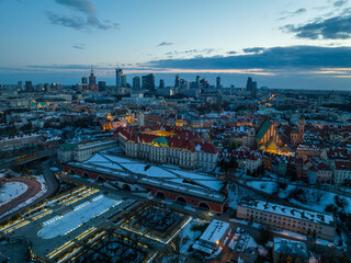 Fototapeta na wymiar Widok na zamek królewki i stare miasto w Warszawie z drona, w tle wieżowce, zaśnieżone dachy, zachód słońca