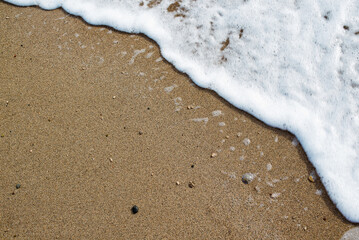 Soft wave of blue ocean on sandy beach. Background.