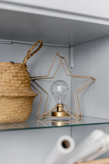 Glass shelf with star lamp and basket. Decor in the interior