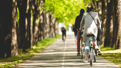 Une personne en train de faire du vélo sur une piste cyclable dans Paris. - obrazy, fototapety, plakaty
