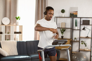 Jogging with pleasure. Young handsome african american man in modern wireless headphones smiling...