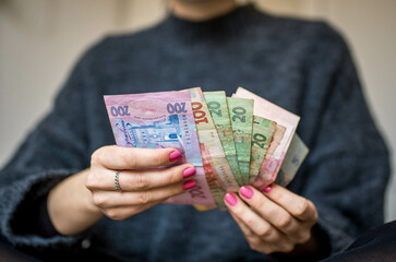 Woman's hands Counting Bills Banknotes of Hryvnias Ukrainian Currency of Different Amounts. Economy and Money Concept