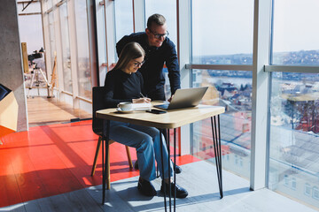 Happy business people are sitting at the table, talking, laughing, discussing business documents, smiling, colleagues are collaborating in the office at a briefing, brainstorming at a meeting