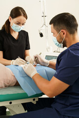 Doctor and nurse during dermatological surgery