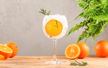 Gin tonic cocktail long drink with dry gin, bitter tonic, orange, rosemary and ice, bar tools. Wooden table background with copy space - obrazy, fototapety, plakaty