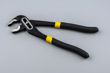 Obraz premium Tongue-and-groove slip-joint pliers detail with movable jaw on a white background.