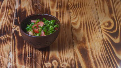 Rustic vegetable salad of fresh vegetables on a brown wooden background