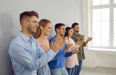 Happy diverse businesspeople applaud thank presenter for meeting or speech. Smiling employees or...
