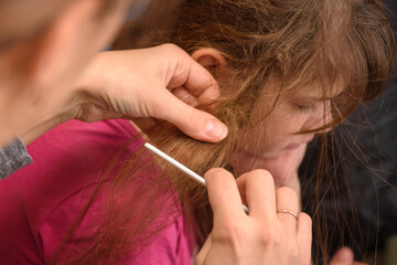 Mom tries to comb the girl's badly tangled hair