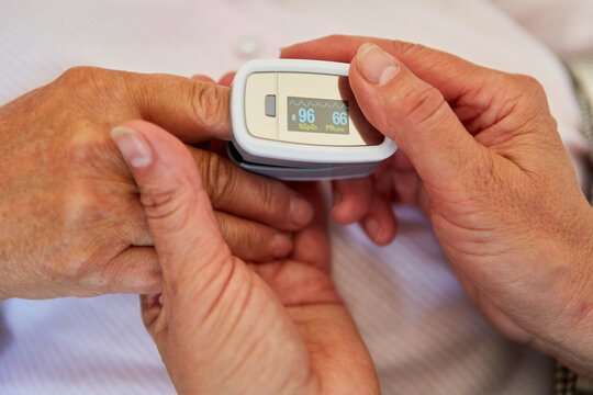 H&auml;nde von Arzt halten Hand von Patient mit Pulsoximeter