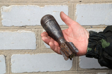 Rusty mortar mine in hand of a soldier