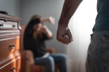 Man with a clenched fist and threatening his wife to assault her, gender violence in the home.