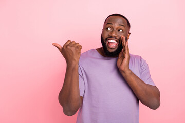 Portrait of attractive cheerful guy showing copy space saying news novelty isolated over pink pastel color background