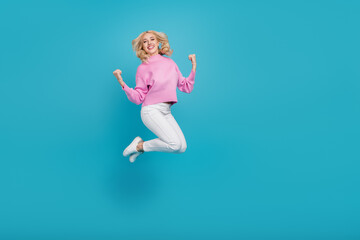 Full length body size view of attractive cheerful wavy-haired girl rejoicing jumping isolated over bright blue color background