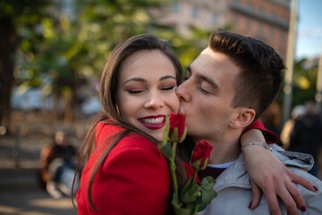 Obraz premium Man giving flowers and kissing his girlfriend