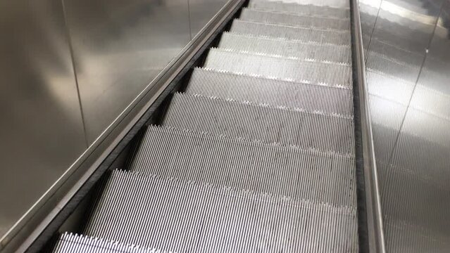 Empty working escalator. POV escalator footage from top to bottom. Shopping mall or underground station 4k background stock video.