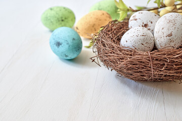 Naklejka na ściany i meble Easter eggs in a nest on a light background. Happy easter concept with copy space