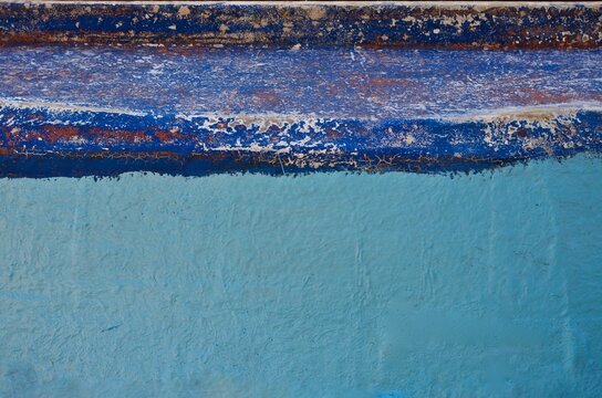 Closeup of the outside of an old blue rowing boat for fishing.