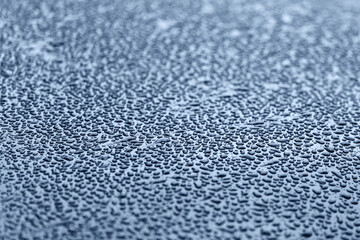 Texture. Water droplets on a dark metal surface