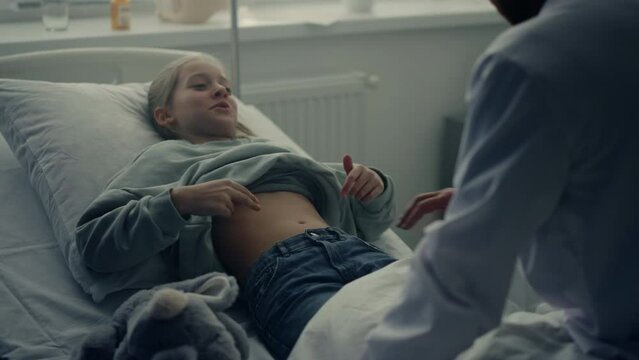 Physician visit patient ward after therapy. Cute girl lying in hospital bed.