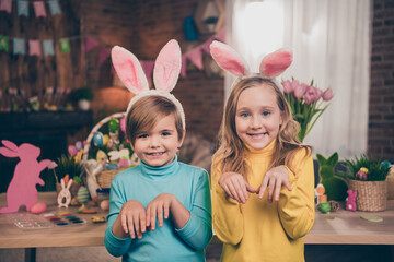 Photo of two funky positive preteen people arms make bunny paws good mood festive atmosphere indoors