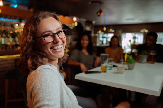 caucasian female smiling while out for dinner with friends