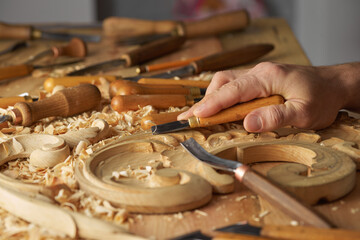 Wood carving, master's hands work with a wooden surface, a professional does wood crafts